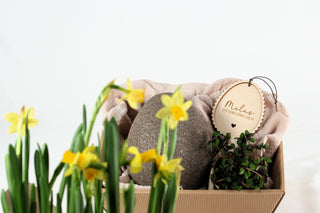 Osterkörbchen mit personalisiertem Oster-Anhänger und Narzissen im Vordergrund