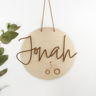 Personalisiertes Holzschild aus hellem Holz mit dem Wunschnamen als 3D-Schriftzug und zartem lasergraviertem Traktor – moderne Wanddeko oder Türschild, ideal als Geschenk zur Geburt oder Taufe. Holzschriftzug
