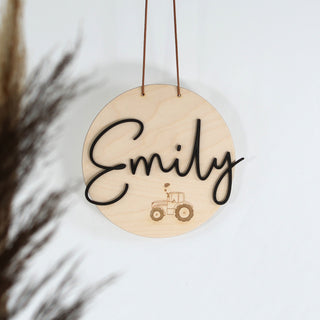 Personalisiertes Holzschild aus hellem Holz mit dem Wunschnamen als 3D-Schriftzug und zartem lasergraviertem Traktor – moderne Wanddeko oder Türschild, ideal als Geschenk zur Geburt oder Taufe. Schwarzer Schriftzug