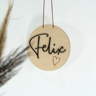 Personalisiertes Namensschild aus Holz mit schwarzem 3D-Schriftzug und kleinem gelaserten Herzmotiv – natürliche Wanddeko, liebevoll gestaltet und perfekt als Geschenk zur Geburt oder Taufe.