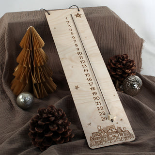 Detailansicht des hölzernen Weihnachts-Countdowns mit gravierten Adventszahlen, kleinen Sternen und beweglichem Sternmarker.