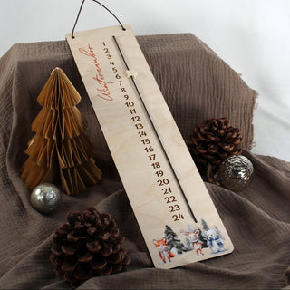 Nahaufnahme des Drucks des weihnachtlichen Tier-Motivs am unteren Ende eines natürlichen Weihnachts-Countdowns aus Holz.