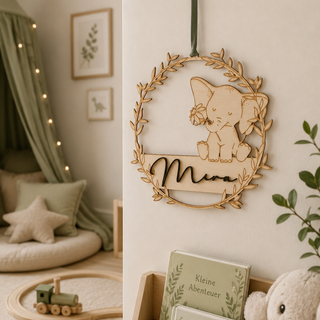 Personalisierbares Namensschild aus Holz „Elefant“ in filigranem Blattreif mit personalisiertem Namensschriftzug dekoriert in einem niedlichen Kinderzimmer.