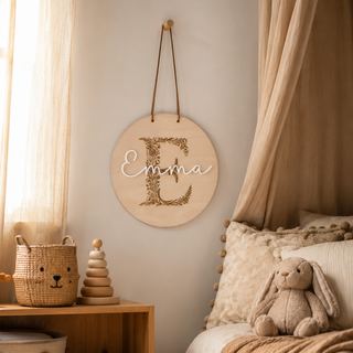 Namensschild rund aus Holz mit Monogramm und aufgesetzem Namen dekoriert in einem Kinderzimmer im Scandi Stil.