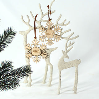 Personalisierte Schneeflocke aus Holz mit eingraviertem Namen – handgefertigter Christbaumanhänger oder Geschenkanhänger für Weihnachten. An schönen Dekorhirschen dekoriert.