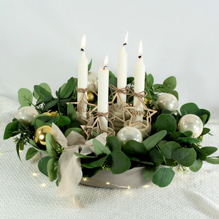 Set aus vier gelaserten Holzanhängern in Sternform mit den Aufschriften eins, zwei, drei und vier – dekoriert an weißen Adventskerzen in schlichtem Adventskranz