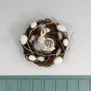 Personalisierter Osteranhänger aus Holz in Hasenform mit filigranem Blumenmuster und Namen. Handgemachte Osterdekoration, dekoriert in einem Oster-Kranz