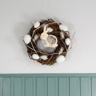Personalisierter Osteranhänger aus Holz in Hasenform mit filigranem Blumenmuster und Namen. Dekoriert mit Osterkranz.