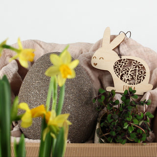 Personalisierter Osteranhänger aus Holz in Hasenform mit filigranem Blumenmuster und Namen. Dekoriert in Osterkörbchen.