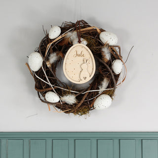 Personalisierter Osteranhänger aus Holz mit 3D-Hasenmotiv und graviertem Namen. Osterlich dekoriert in einem Kranz.