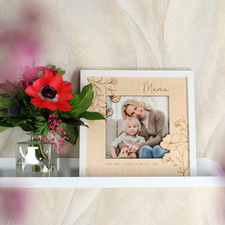 Anwendungsszene Bilderrahmen aus Holz mit Foto von Mutter und Kind als liebevolle Deko. Auf regal vor beiger Wand mit Blumenstrauß.
